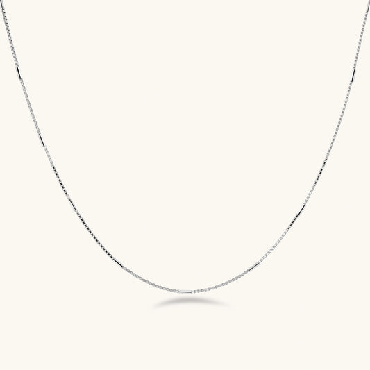 Delicate platinum-plated sterling silver necklace with alternating textured cubic links and smooth chain sections.