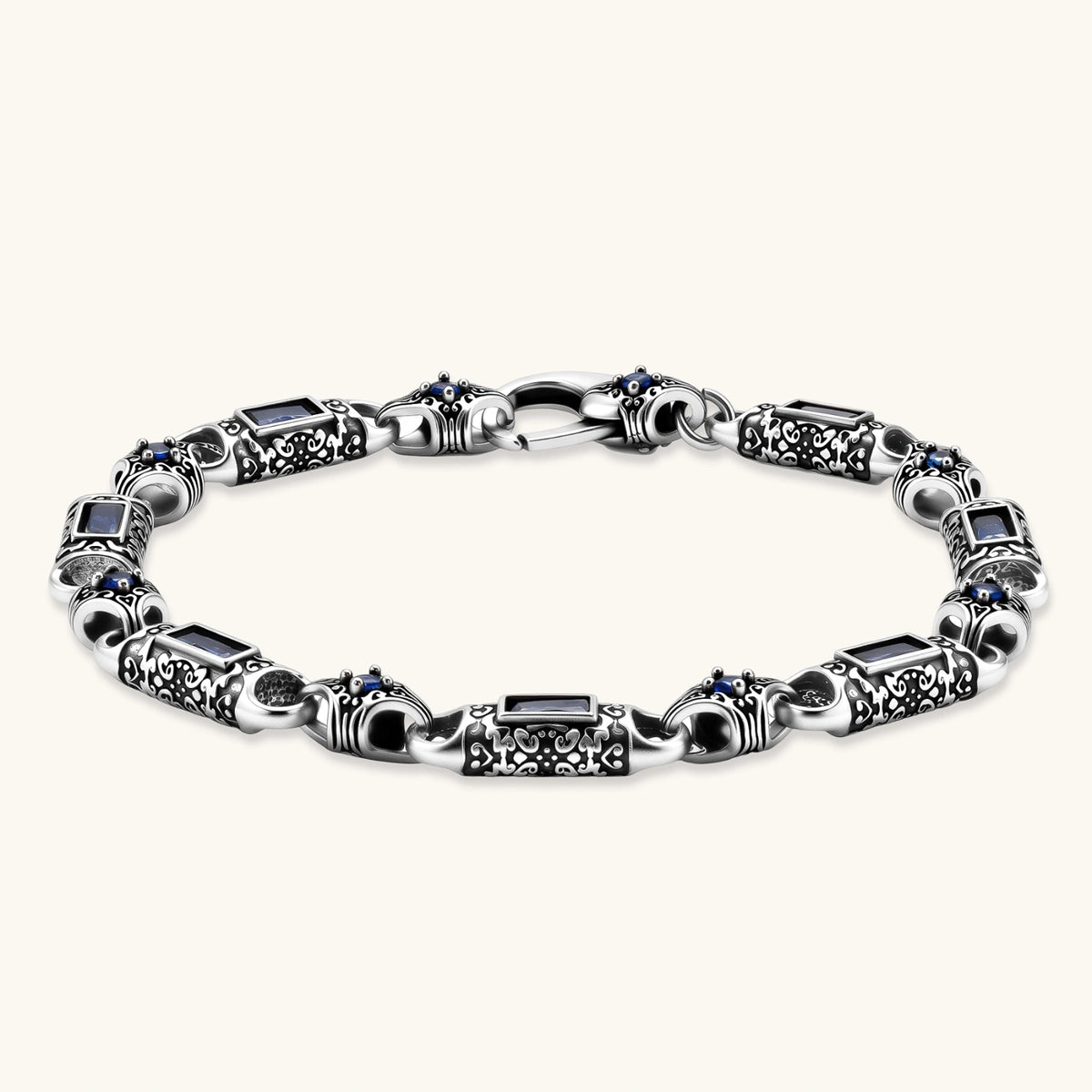 Antique silver plated eco-brass link bracelet with engraved scrollwork, blue baguette cubic zirconia and a lobster clasp.