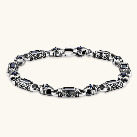 Antique silver plated eco-brass link bracelet with engraved scrollwork, blue baguette cubic zirconia and a lobster clasp.