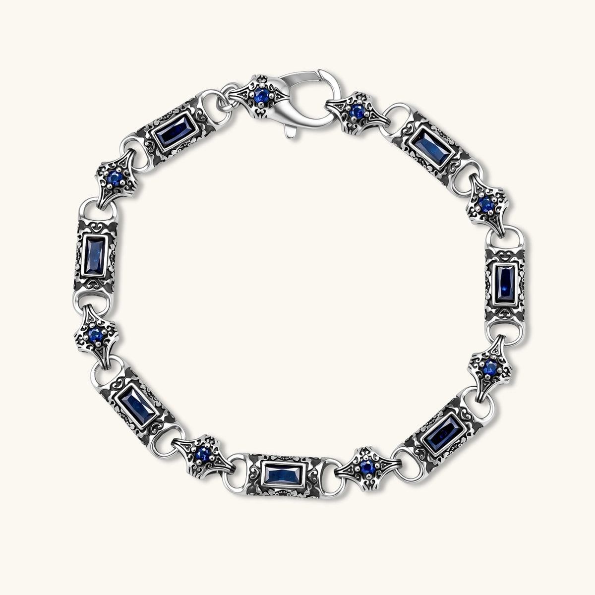 Antique silver plated eco-brass link bracelet with engraved scrollwork, blue baguette cubic zirconia and a lobster clasp.