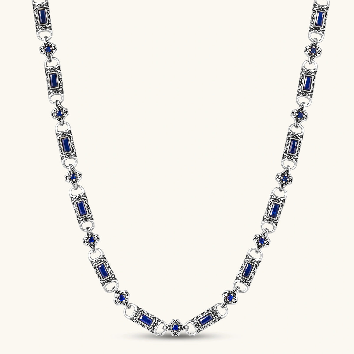 Antique silver plated eco-brass link necklace with blue baguette and round cubic zirconia in ornate scrollwork settings.